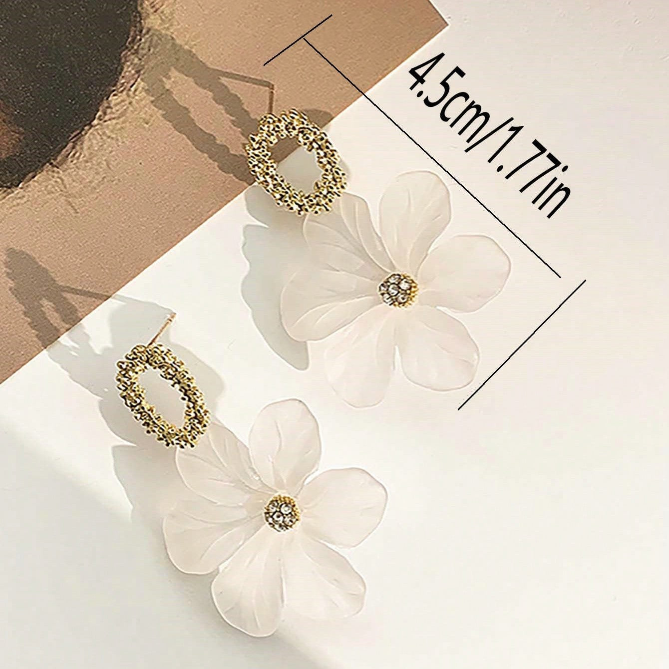 White floral earrings with gold accents
